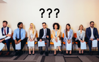 People sitting in a row waiting to be interviewed with questions marks above reflecting the question - Why is so hard to hire in 2026?